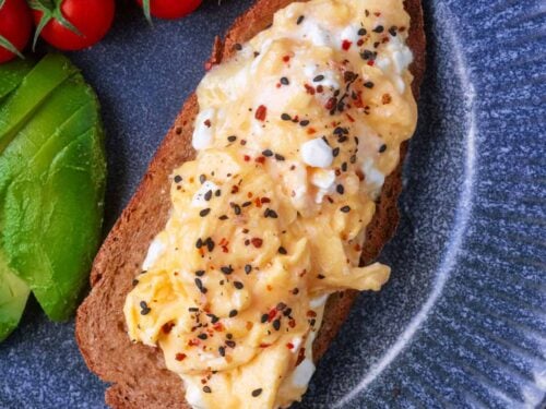 Scrambled eggs with cottage cheese on a slice of toast.