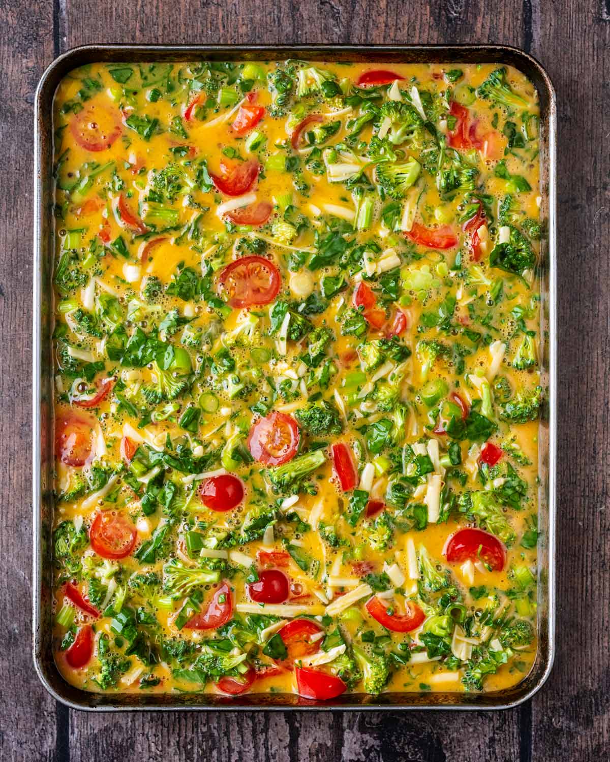 The egg and vegetable mixture poured into a sheet pan.
