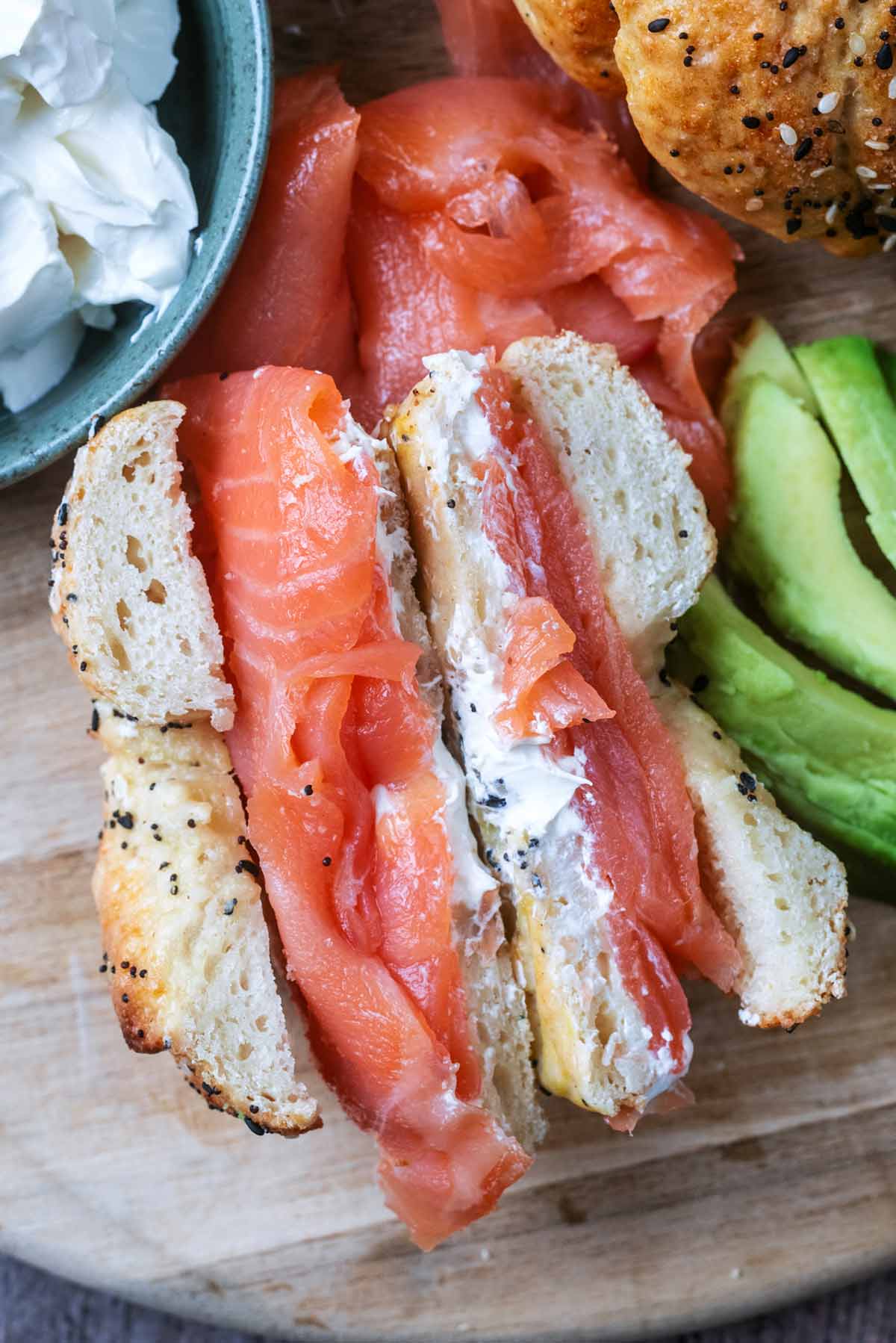 A cream cheese and smoked salmon bagel sliced in half showing the insides.