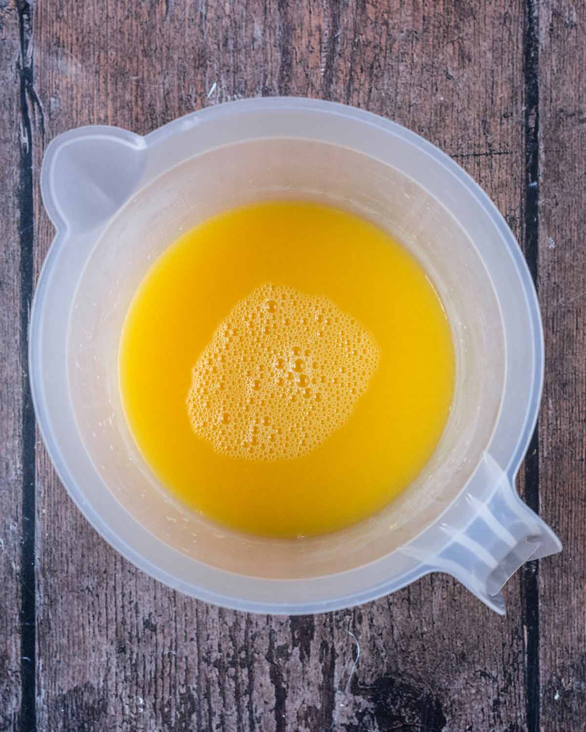 The gelatine mixture added to a jug of orange juice.