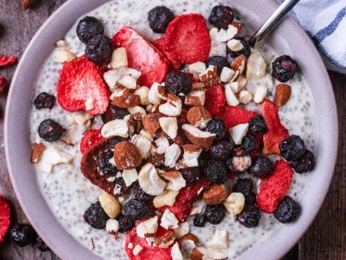 A bowl of Greek yogurt chia pudding topped with berries and crushed nuts.