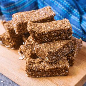 A stack of homemade protein bars on a wooden serving board.