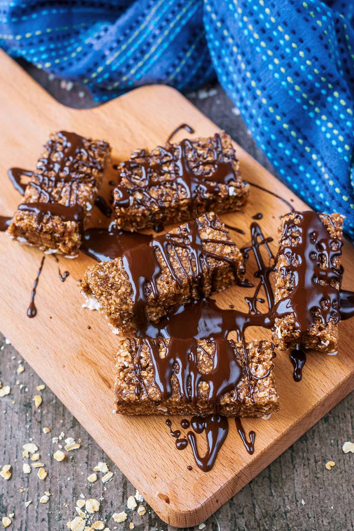 Five protein bars with melted chocolate drizzled over them.