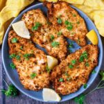 A plate of four air fryer chicken cutlets.