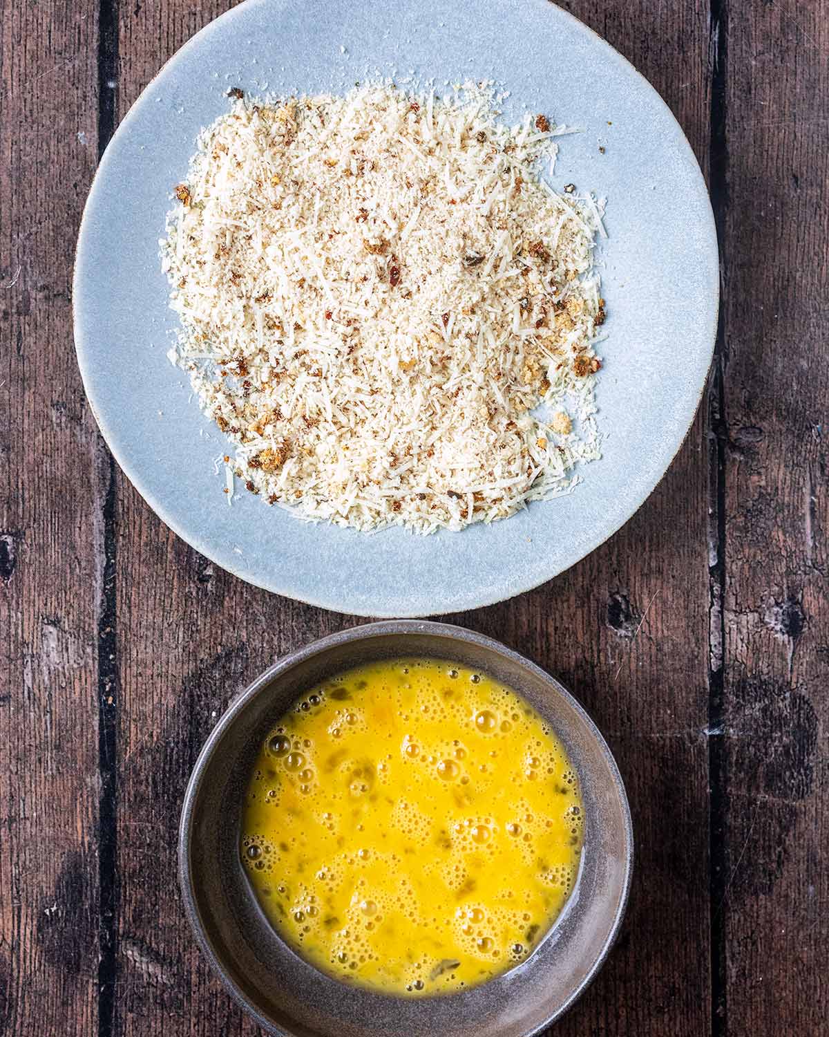 A plate of seasoned breadcrumbs and a bowl of whisked egg.