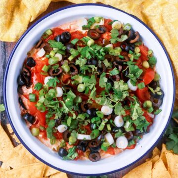 A bowl of cottage cheese taco dip surrounded by tortilla chips.