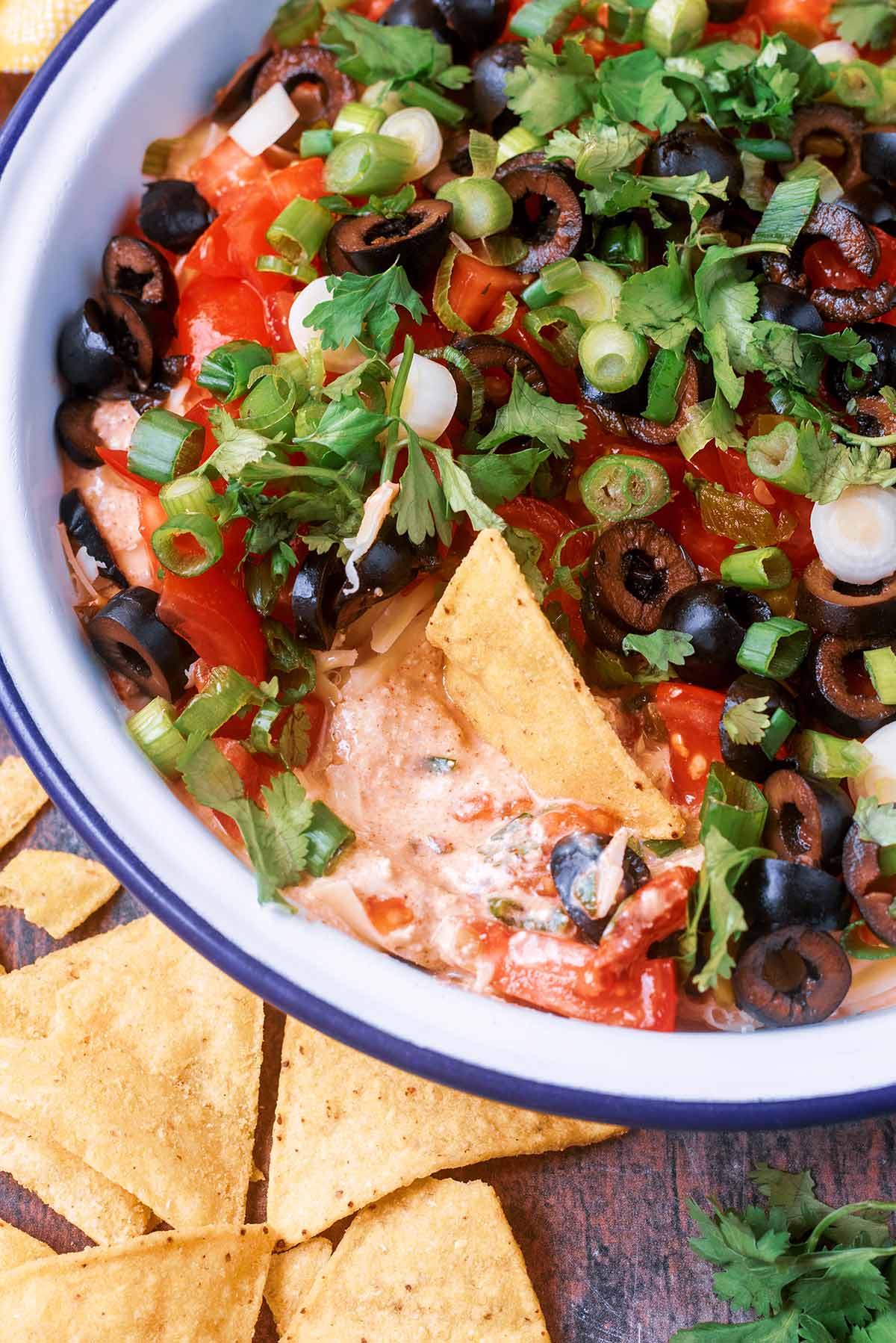 A tortilla chip in a bowl of taco dip.