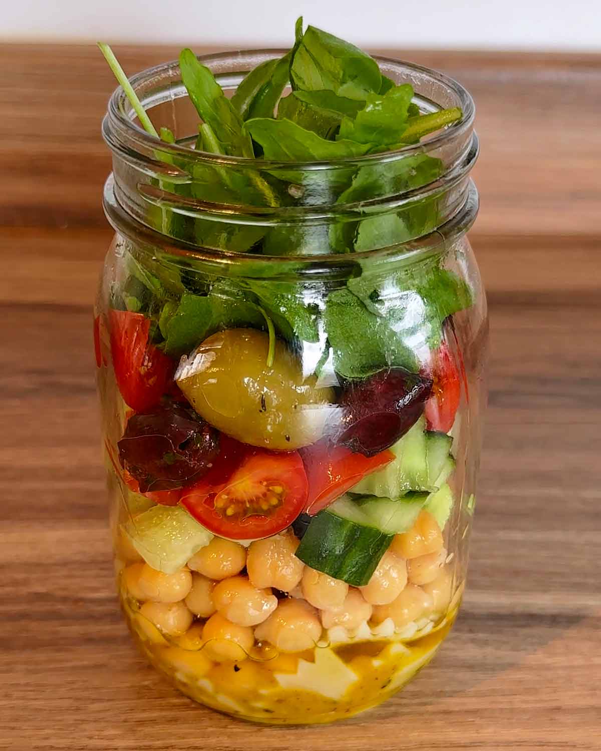 Chickpeas, cucumber, tomatoes, olives and rocket added to the jar.