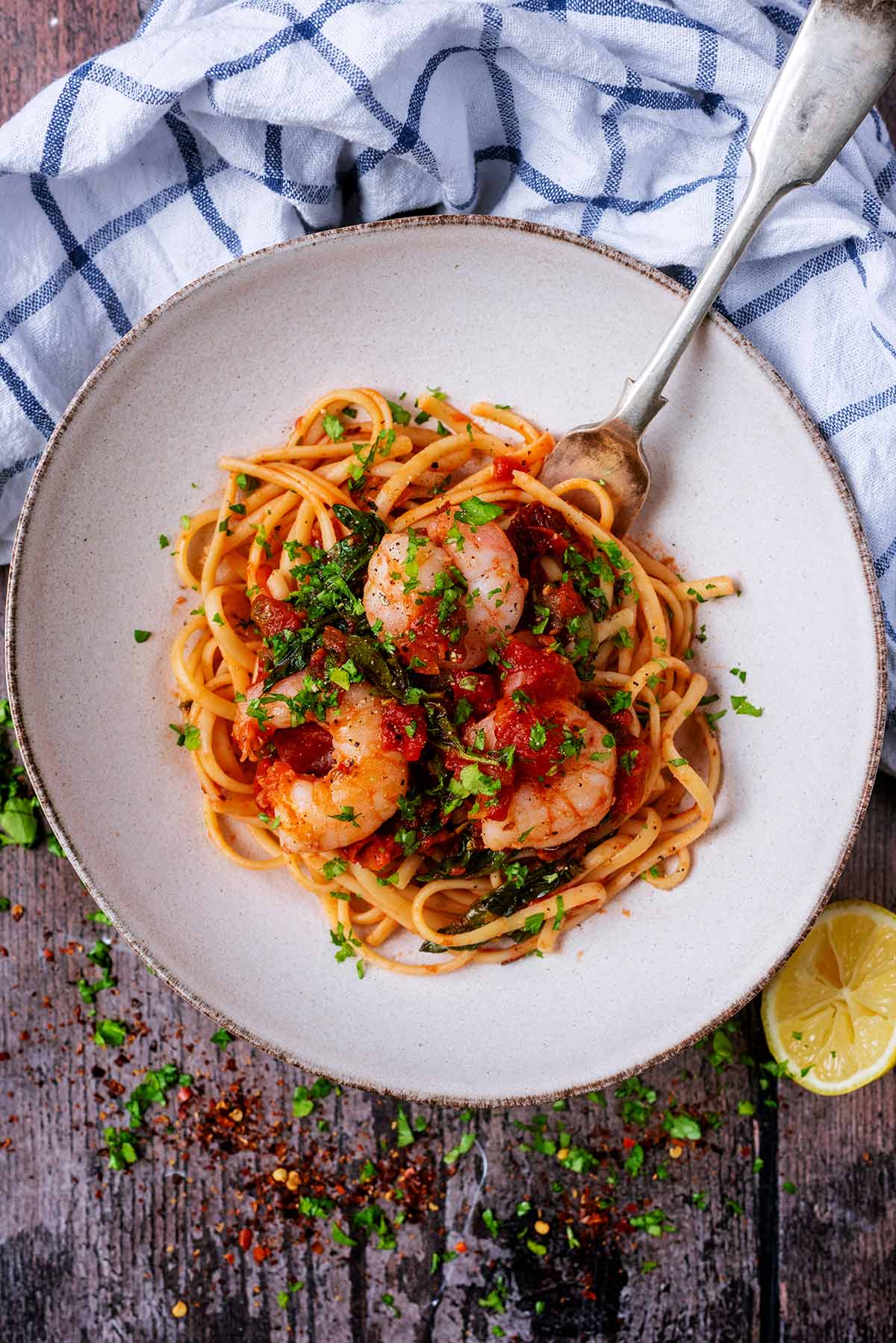 King prawn linguine in a shallow bowl with a fork in it.