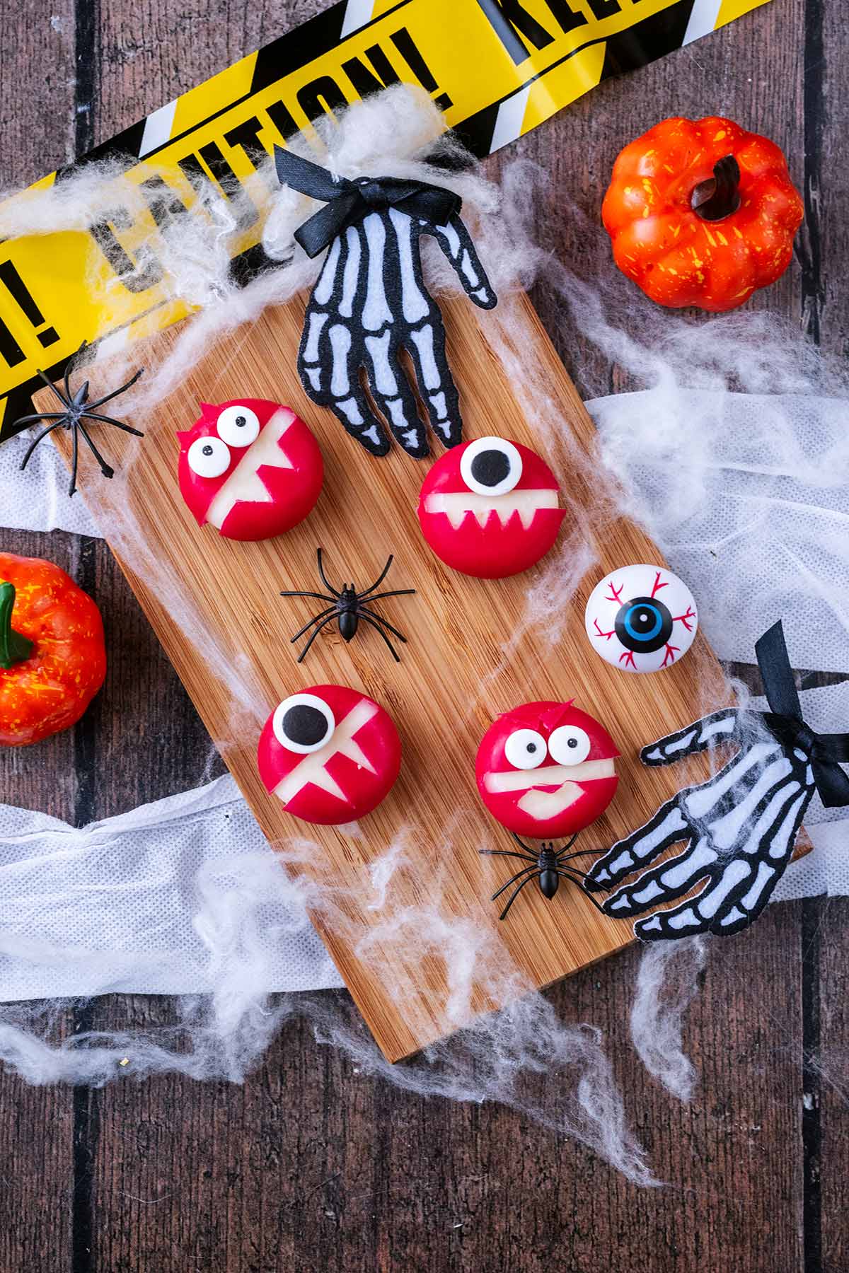 Four Babybel cheeses with the wax cut to make scary faces.