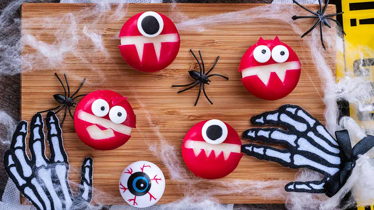 Babybel cheese monsters on a wooden serving board.