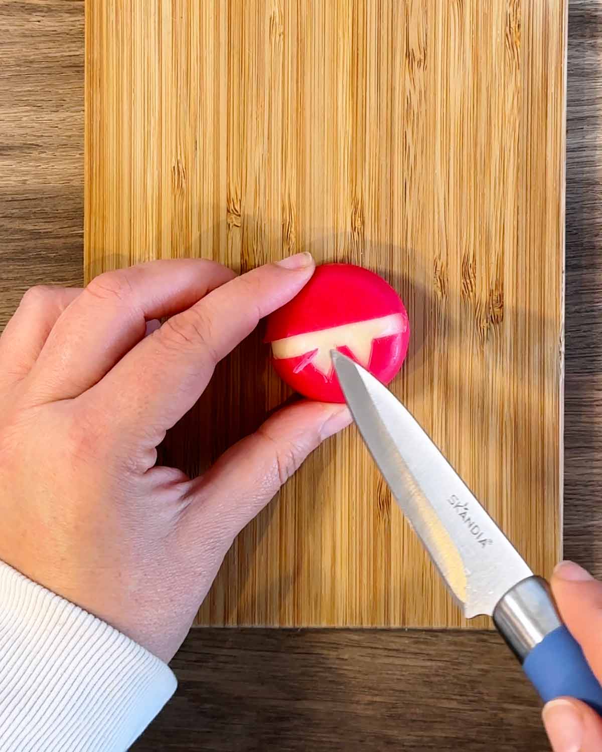 Someone carving a face into Babybel wax.