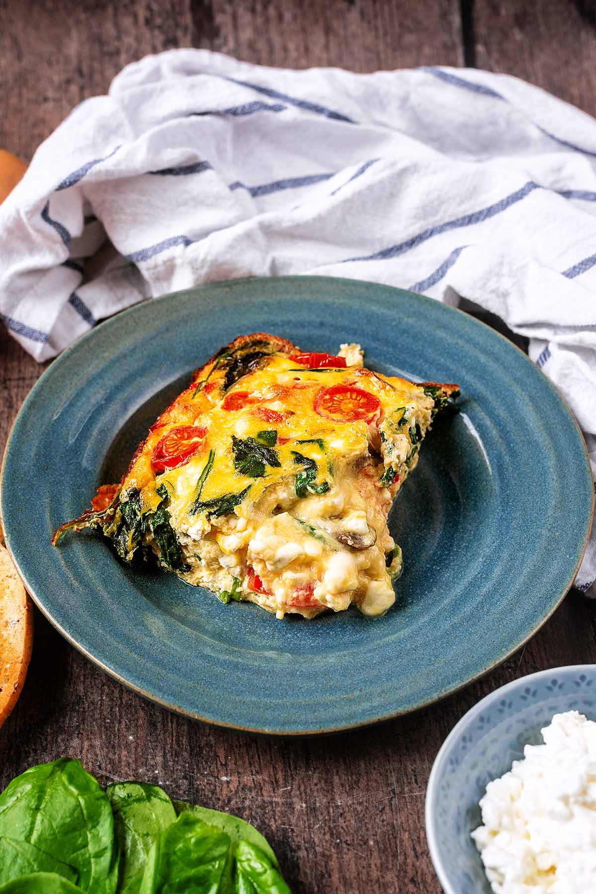 A portion of vegetable frittata on a blue plate.