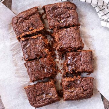 Eight healthy Greek yogurt brownies on a sheet of baking paper.