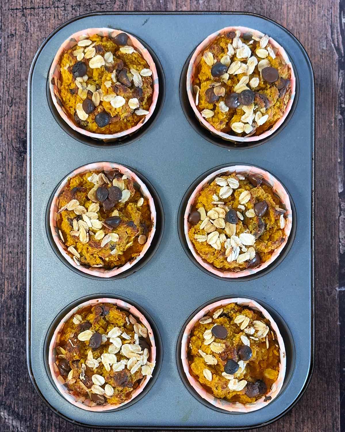 Cooked pumpkin muffins in a muffin tin.