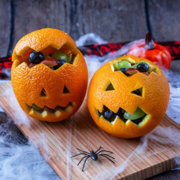 Two oranges cut to resemble Jack O'Lantern.