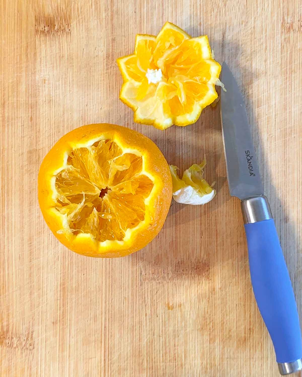 An orange with the top cut off in a zigzag pattern.