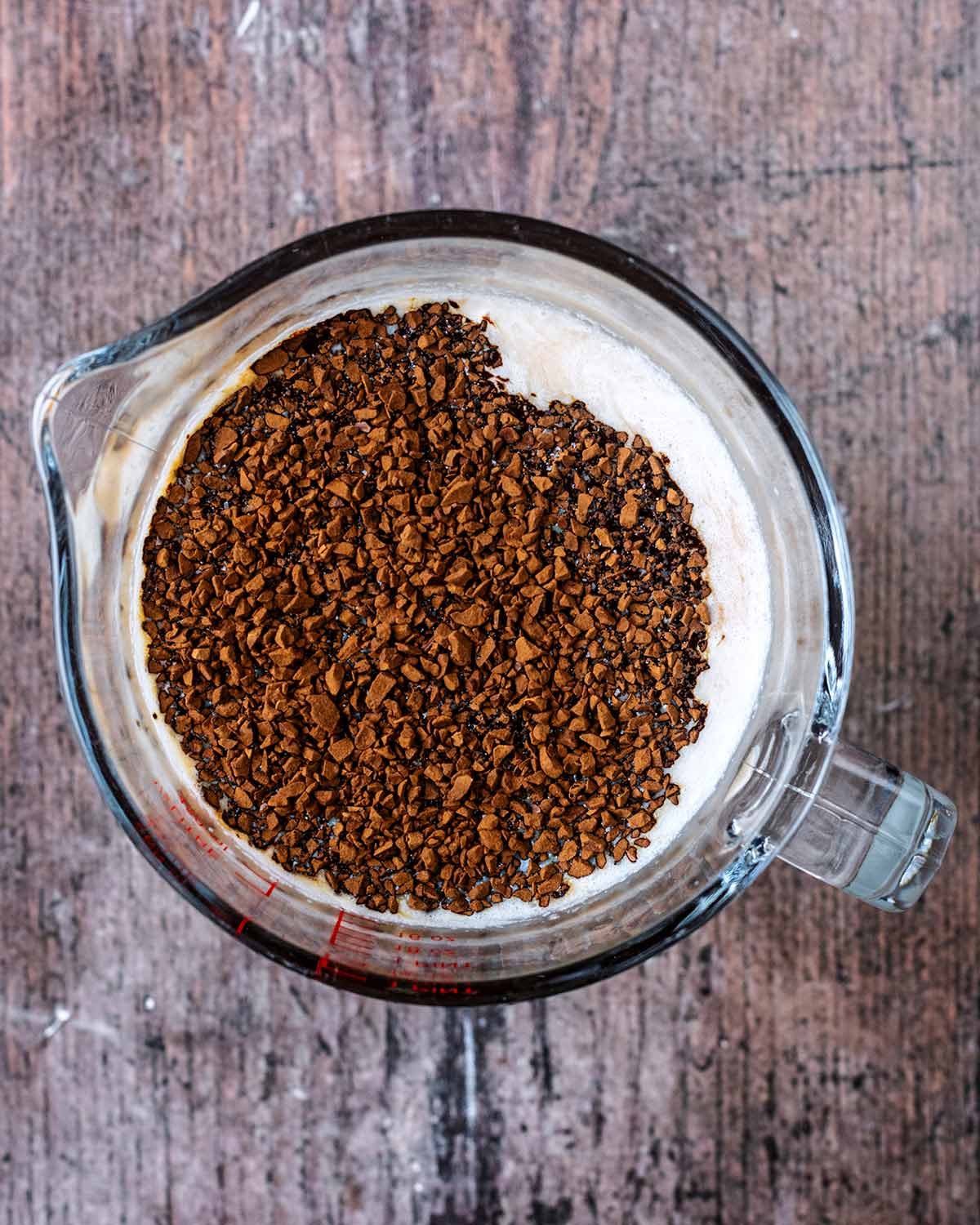 A jug containing milk and coffee granules.