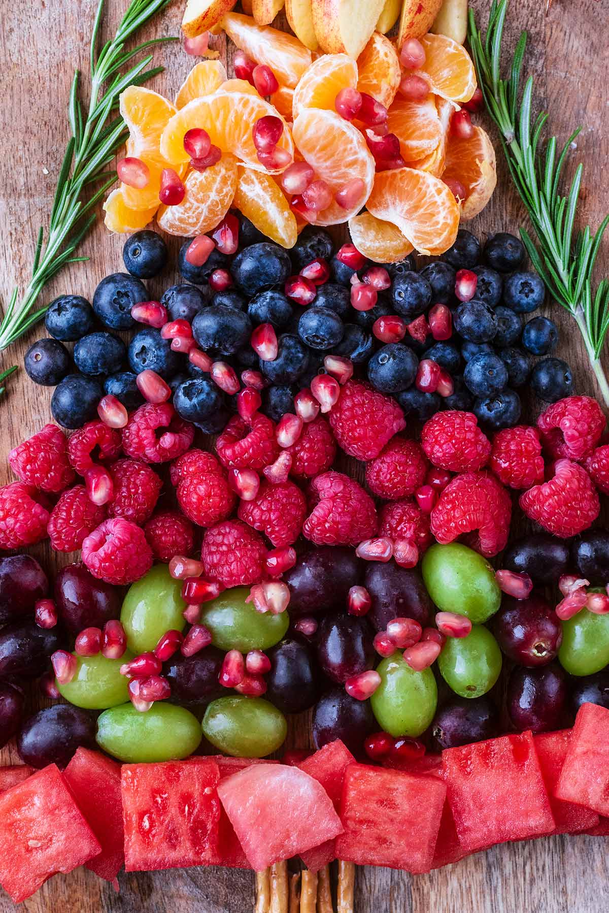 Various fruits and berries arranged in rows.