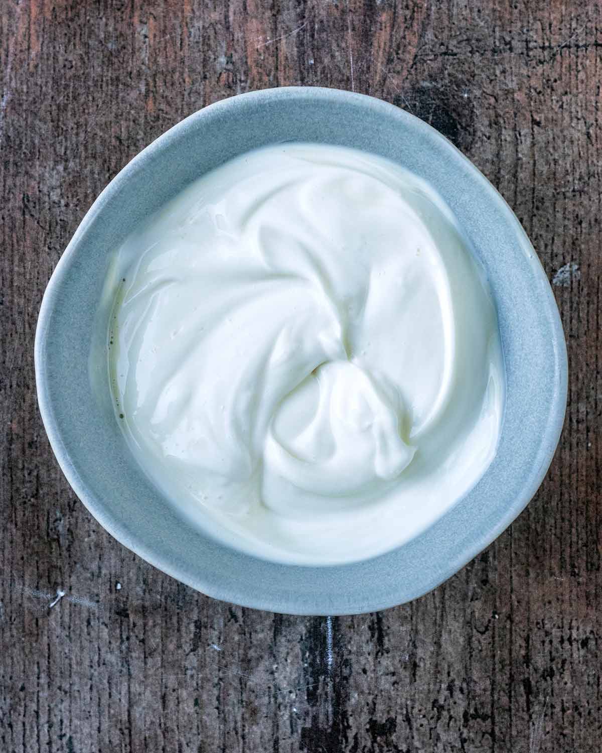 Yogurt and maple syrup mixed together in a bowl.