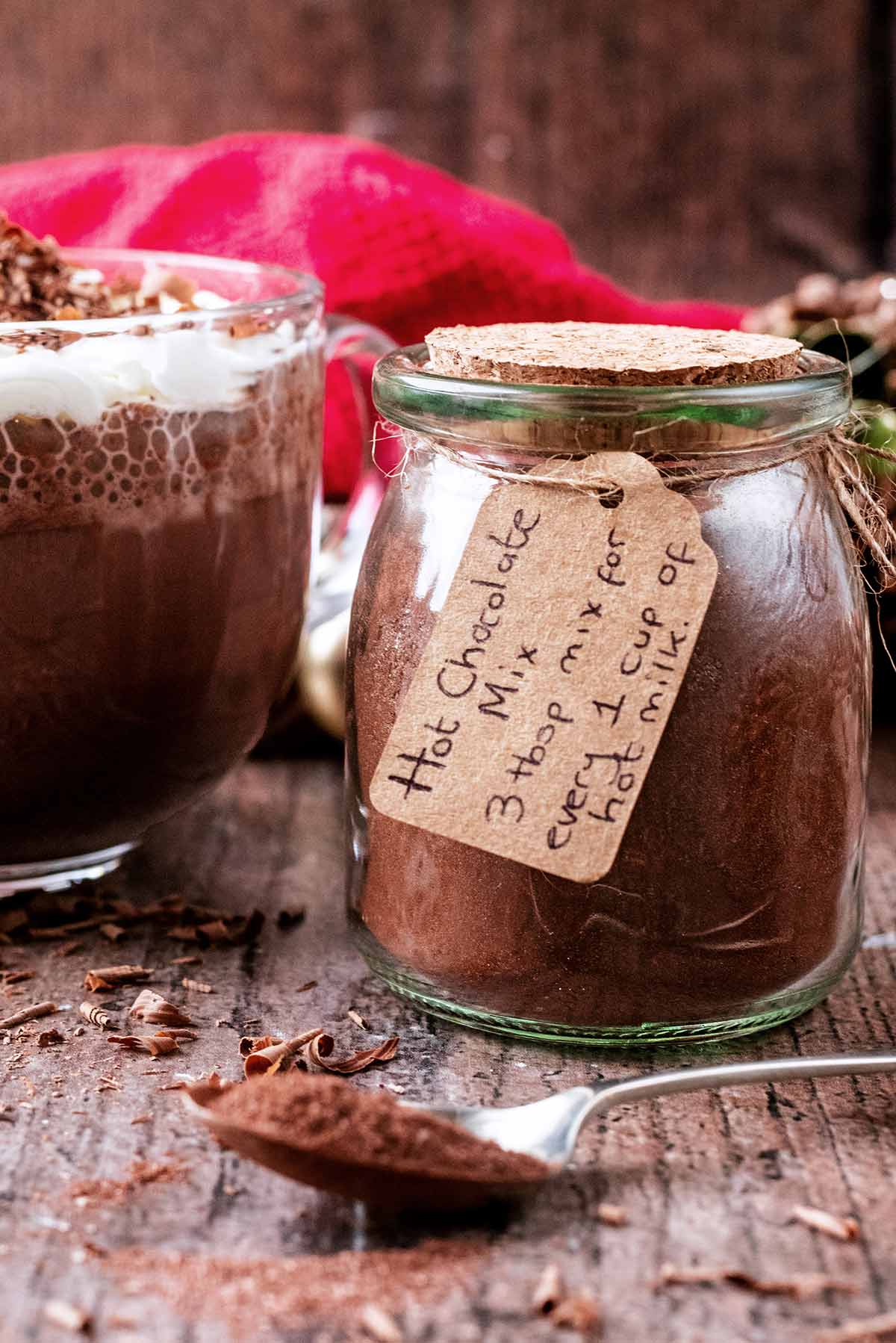 Hot chocolate powder in a small glass jar with a gift label.