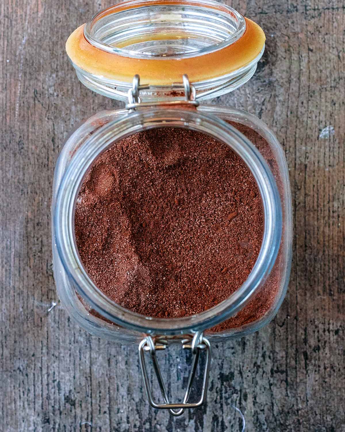 A glass jar with the lid open showing hot chocolate mixture inside.