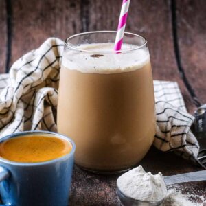 A glass of protein iced coffee with a shot of espresso in front of it.