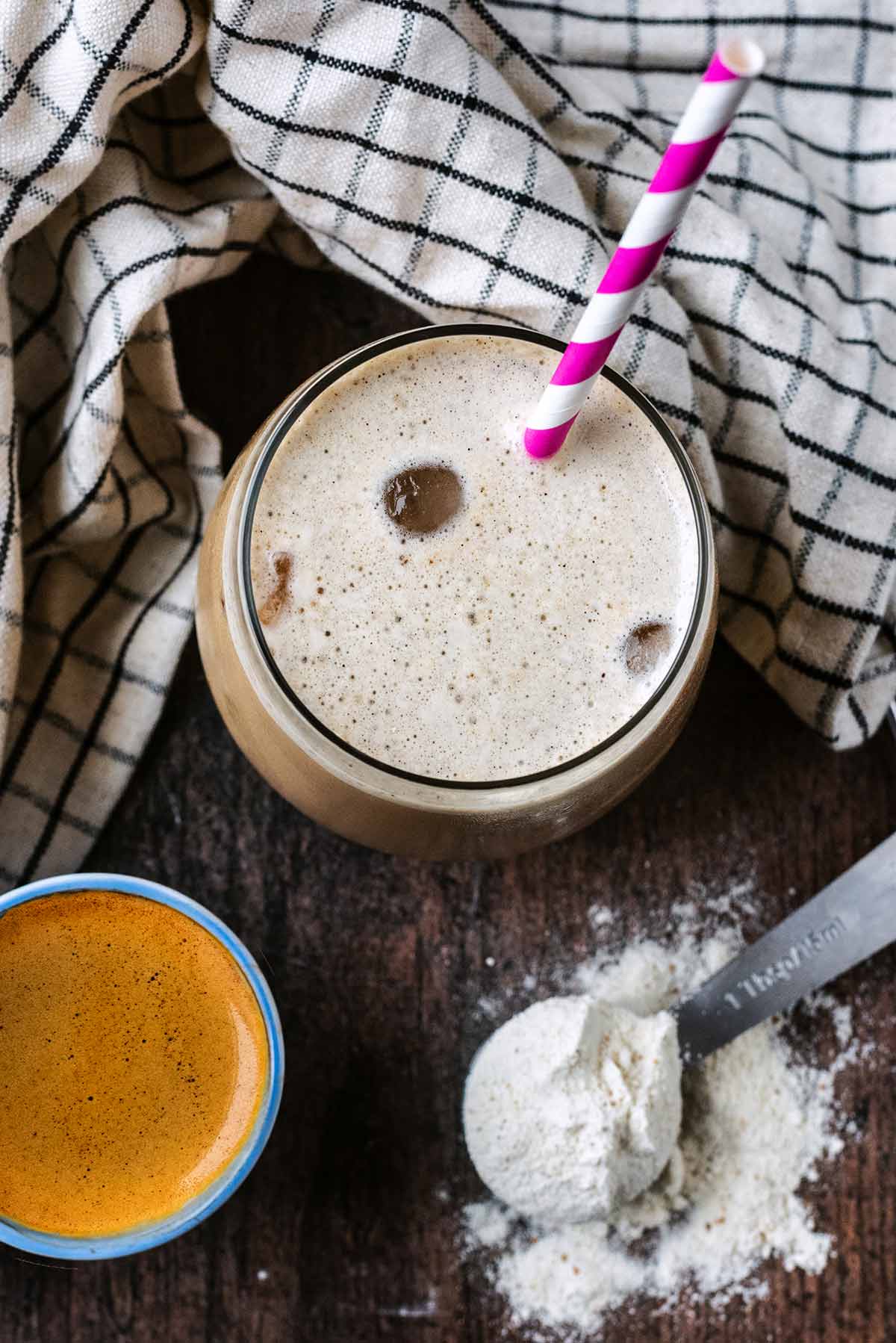 A glass of iced coffee with a straw in it.