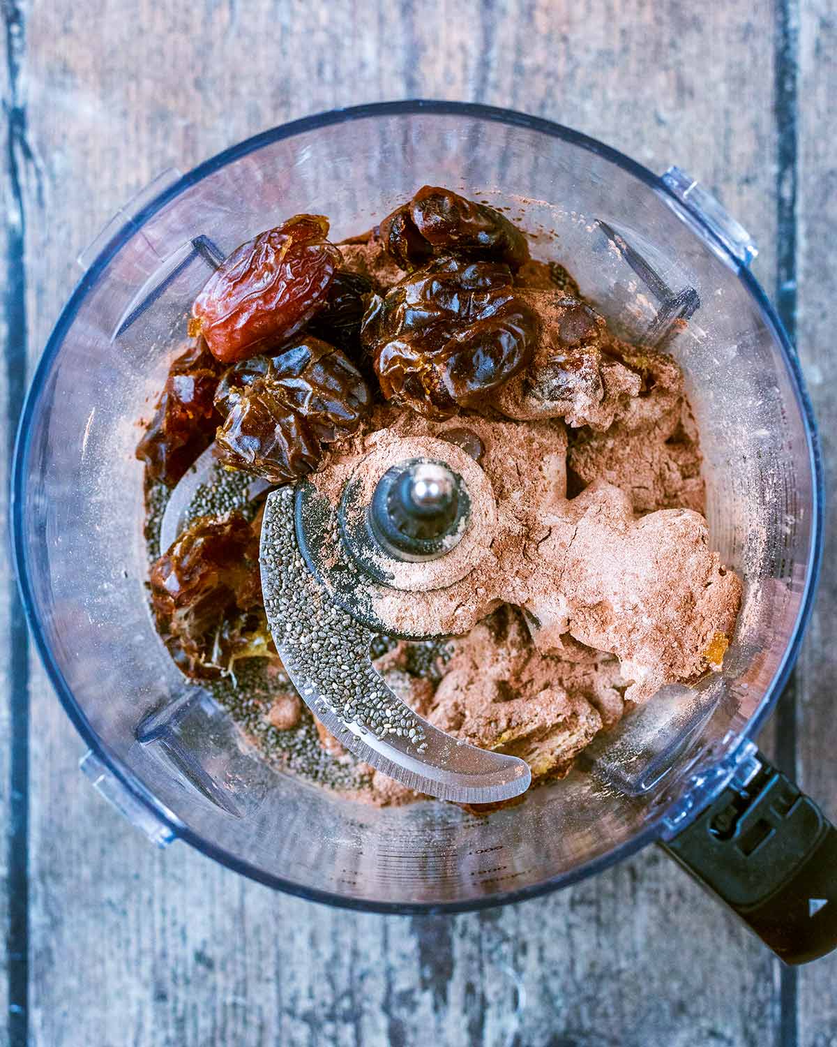 Dates, dried fruit, seeds and cacao powder in a food processor.