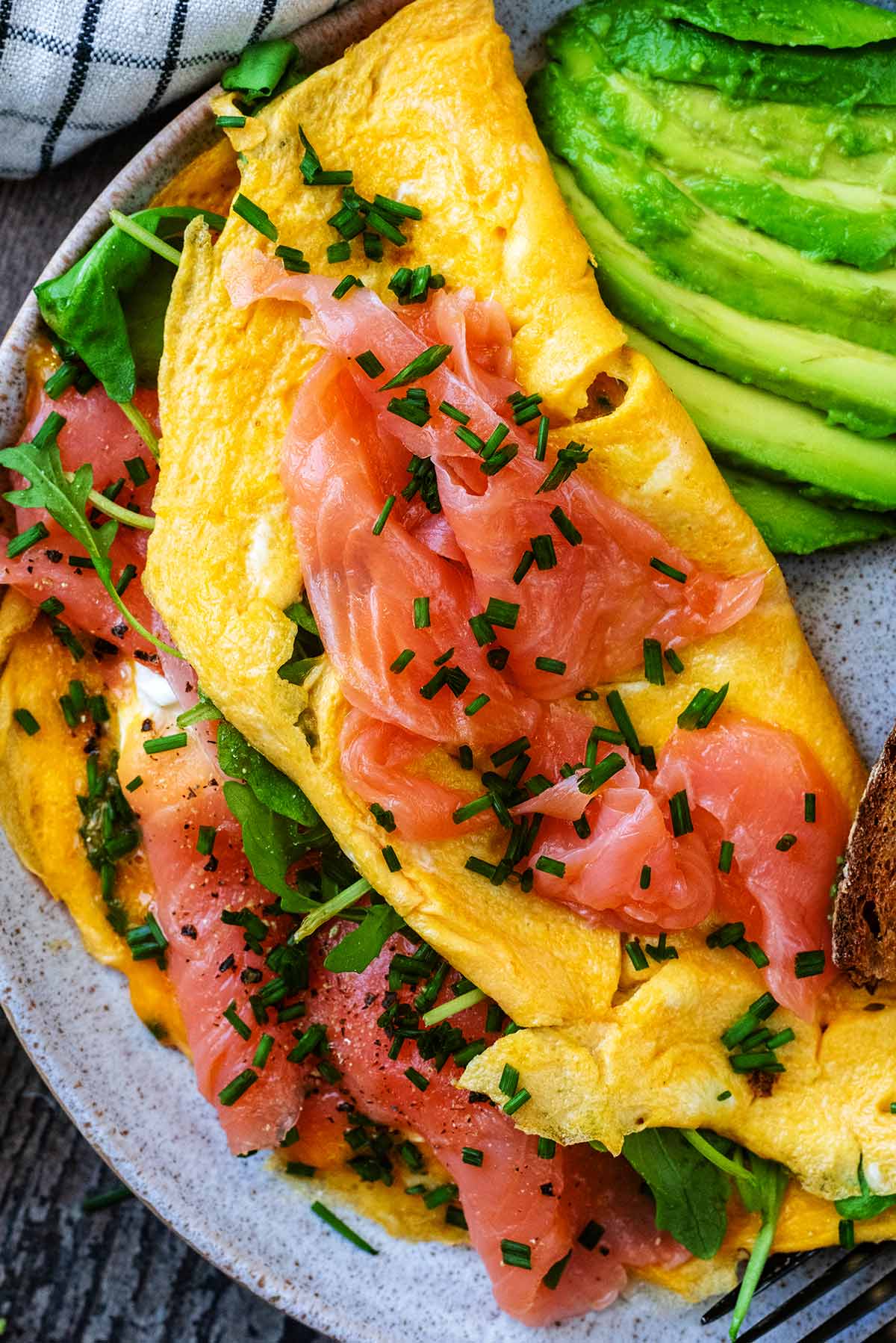 A folded omelette with smoked salmon and rocket lettuce for a filling.