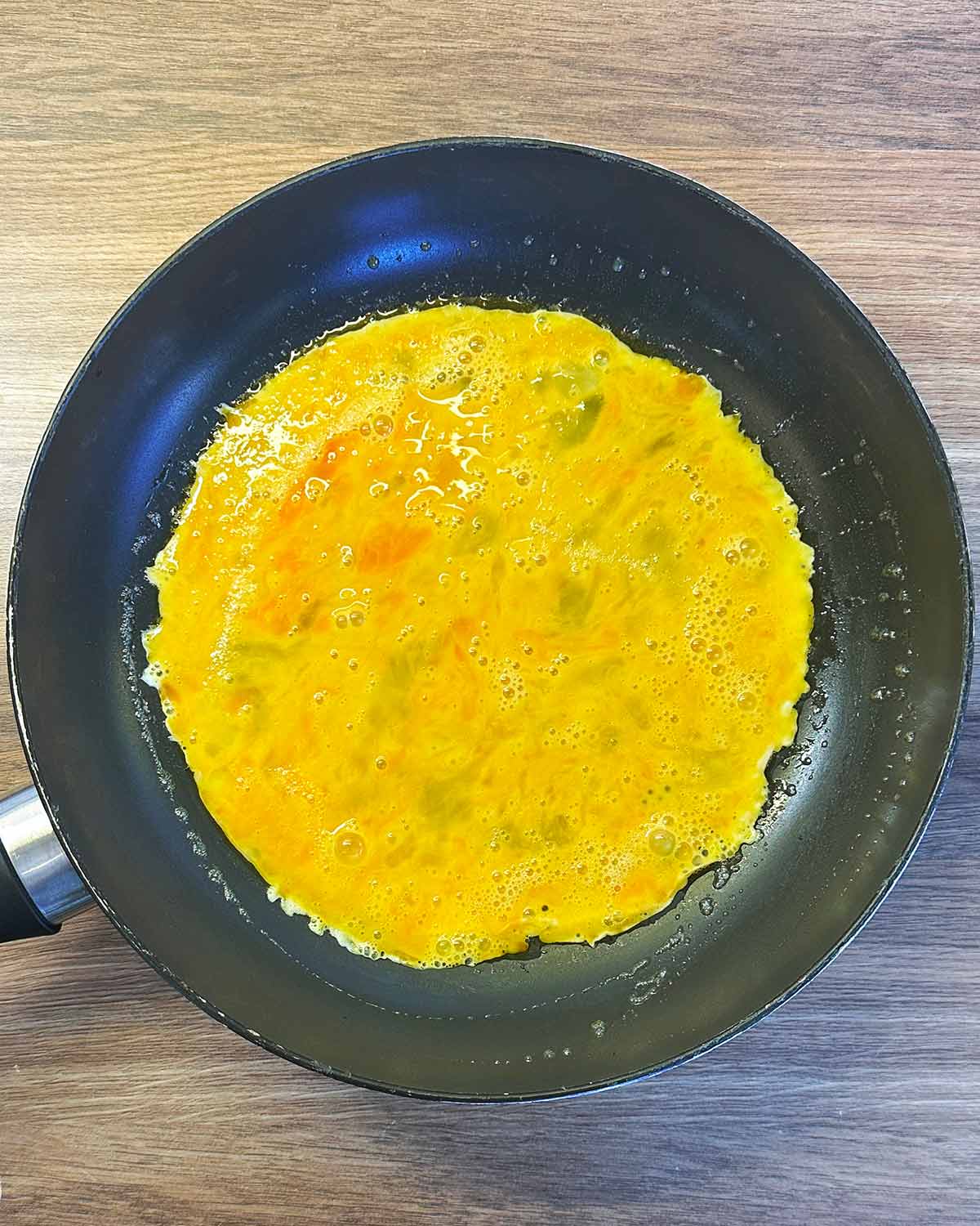 Whisked eggs in a frying pan.