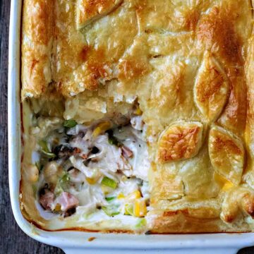 Chicken and ham pie with a corner portion removed.