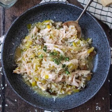 A bowl of leftover turkey risotto in a round grey bowl.