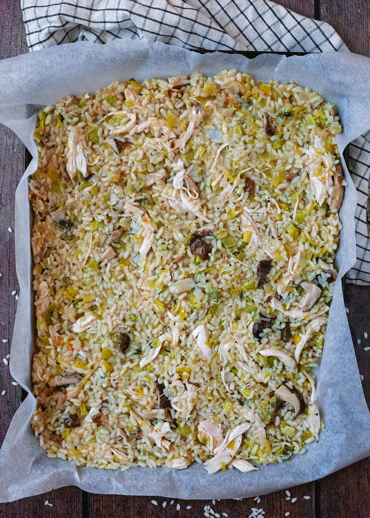 Risotto spread out over a large lined baking sheet.