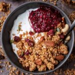 A bowl of yogurt topped with berry compote and air fryer granola.