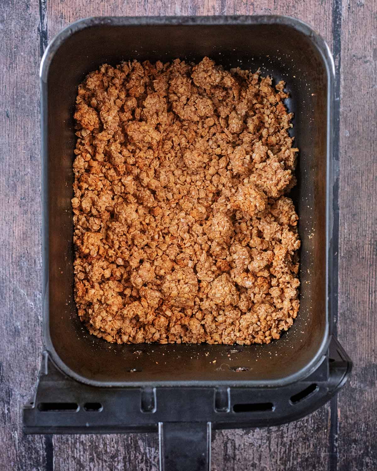 Cooked granola in an air fryer basket.