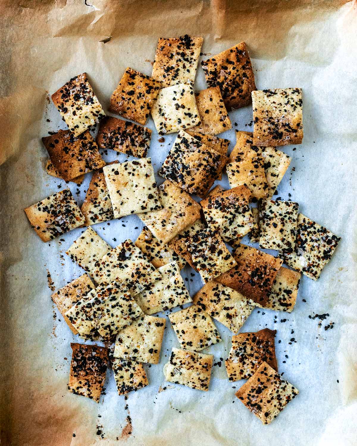 the dough cracked into individual crackers, all on a lined baking sheet.