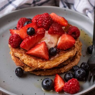 A stack of Greek yogurt pancakes topped with berries.