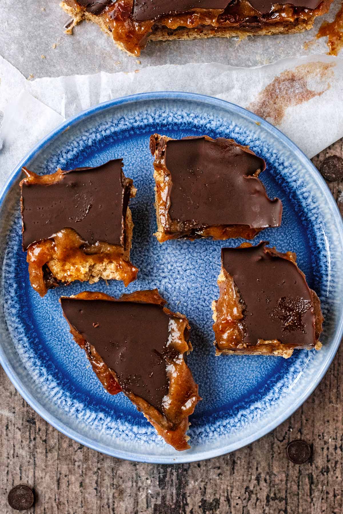 Four pieces of millionaire shortbread on a round plate.