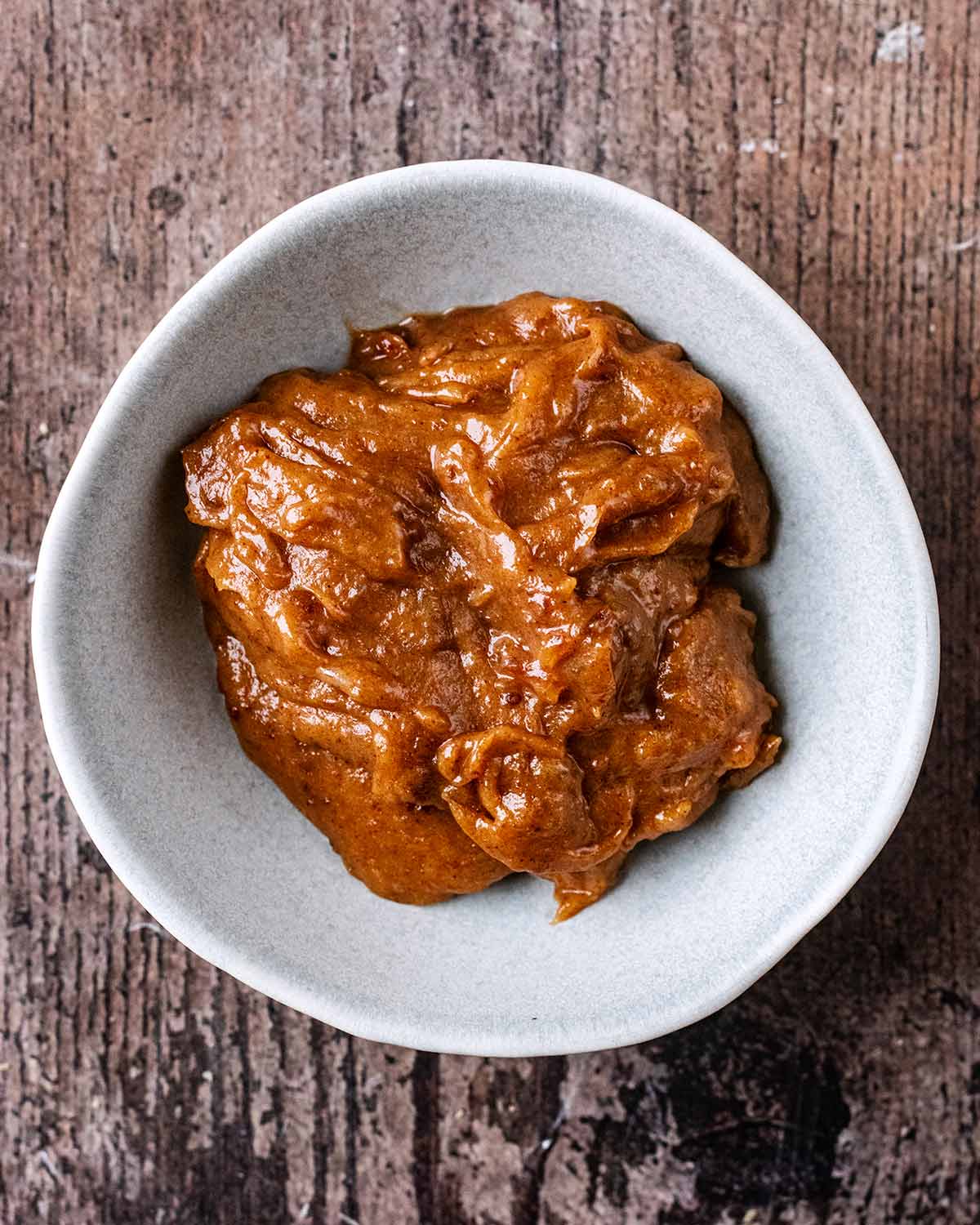 A small round bowl with healthy caramel in it.