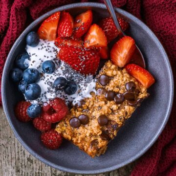 A bowl of oatmeal breakfast cake, yogurt and berries.