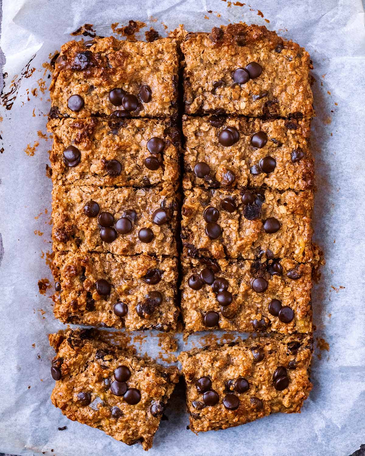 Baked and sliced oatmeal cake on a sheet of parchment paper.