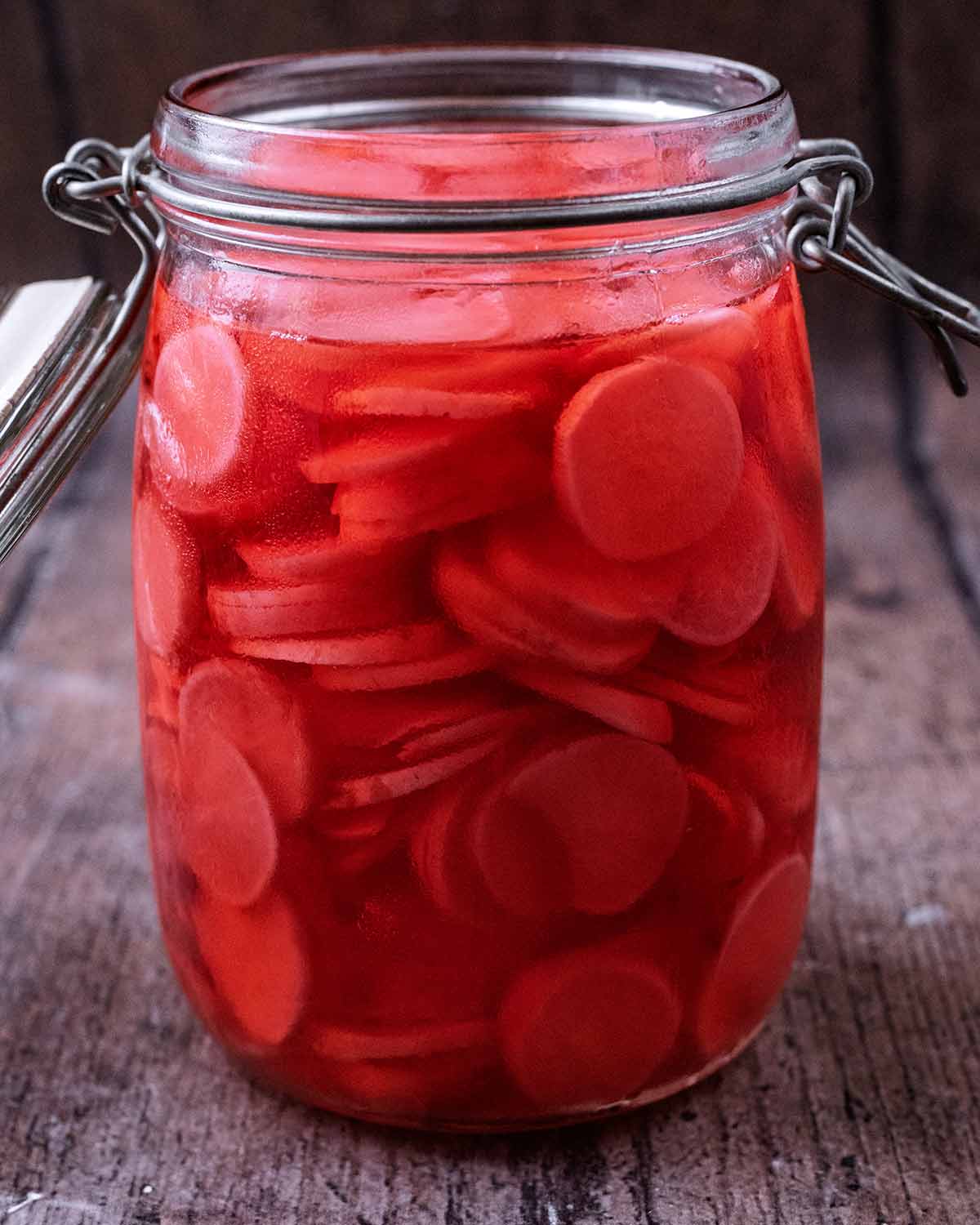 Pickled radishes in pickling juice in a jar.