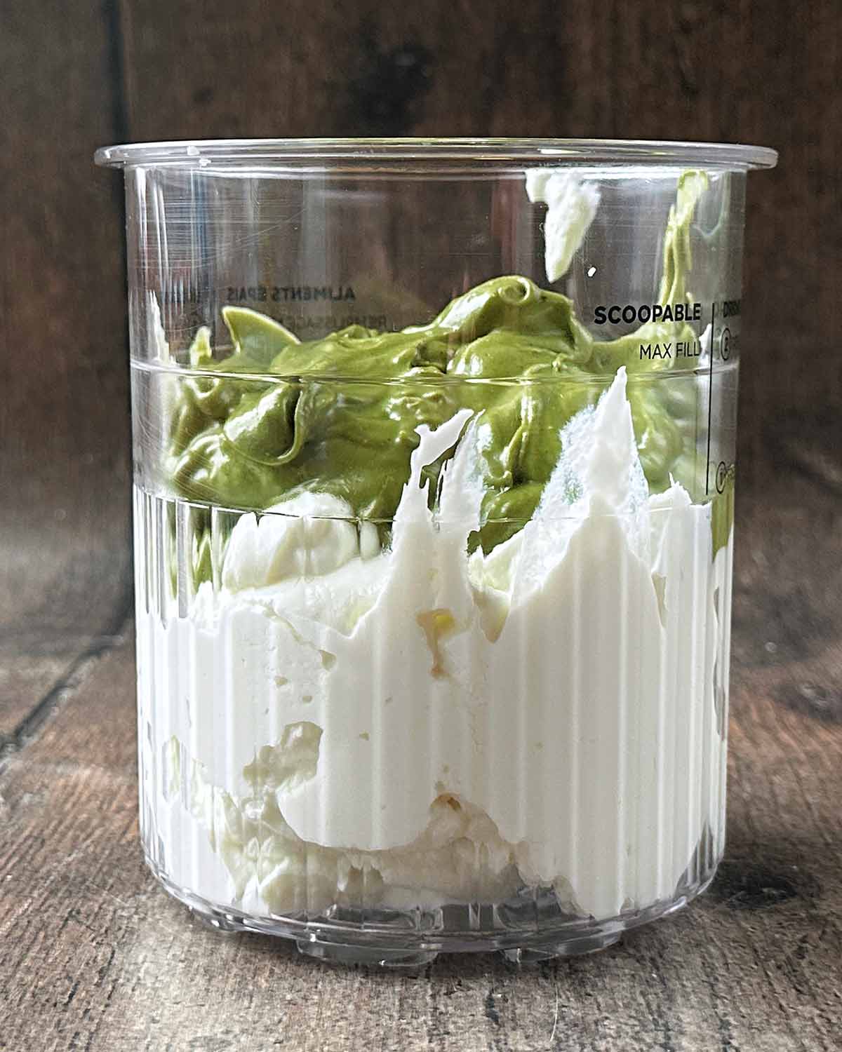 A Ninja Creami tub containing yogurt and pistachio cream.