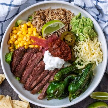 A high protein steak and rice bowl next to a checked towel.