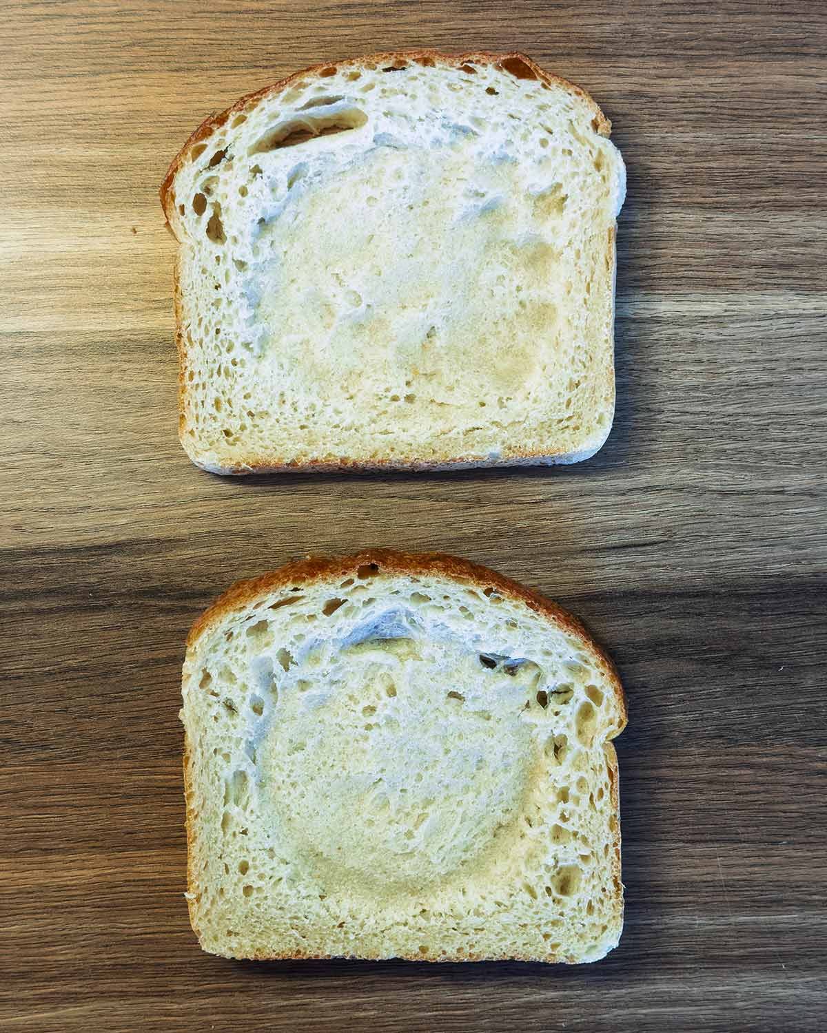 Two slices of bread with circular impressions in them.