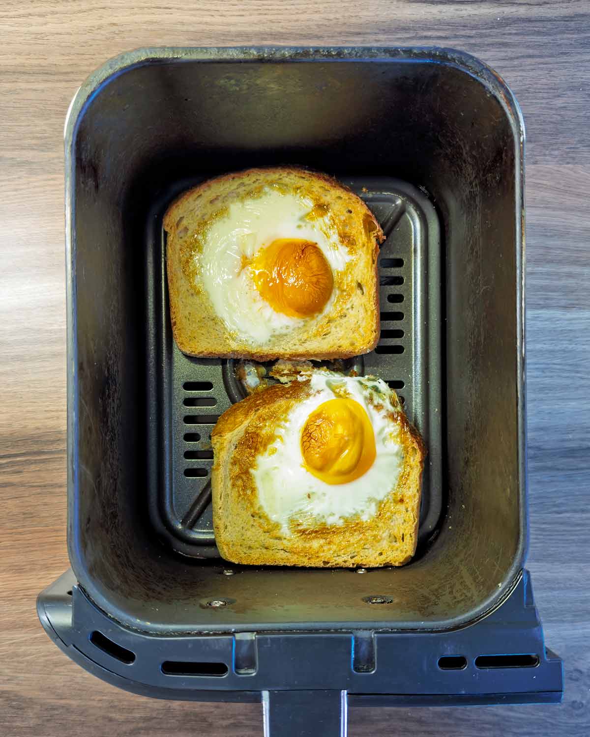 Cooked egg toast in the air fryer basket.