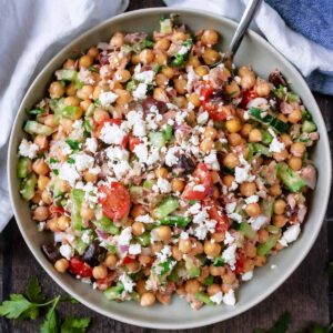 A large bowl of chickpea tuna salad with a serving spoon in it.