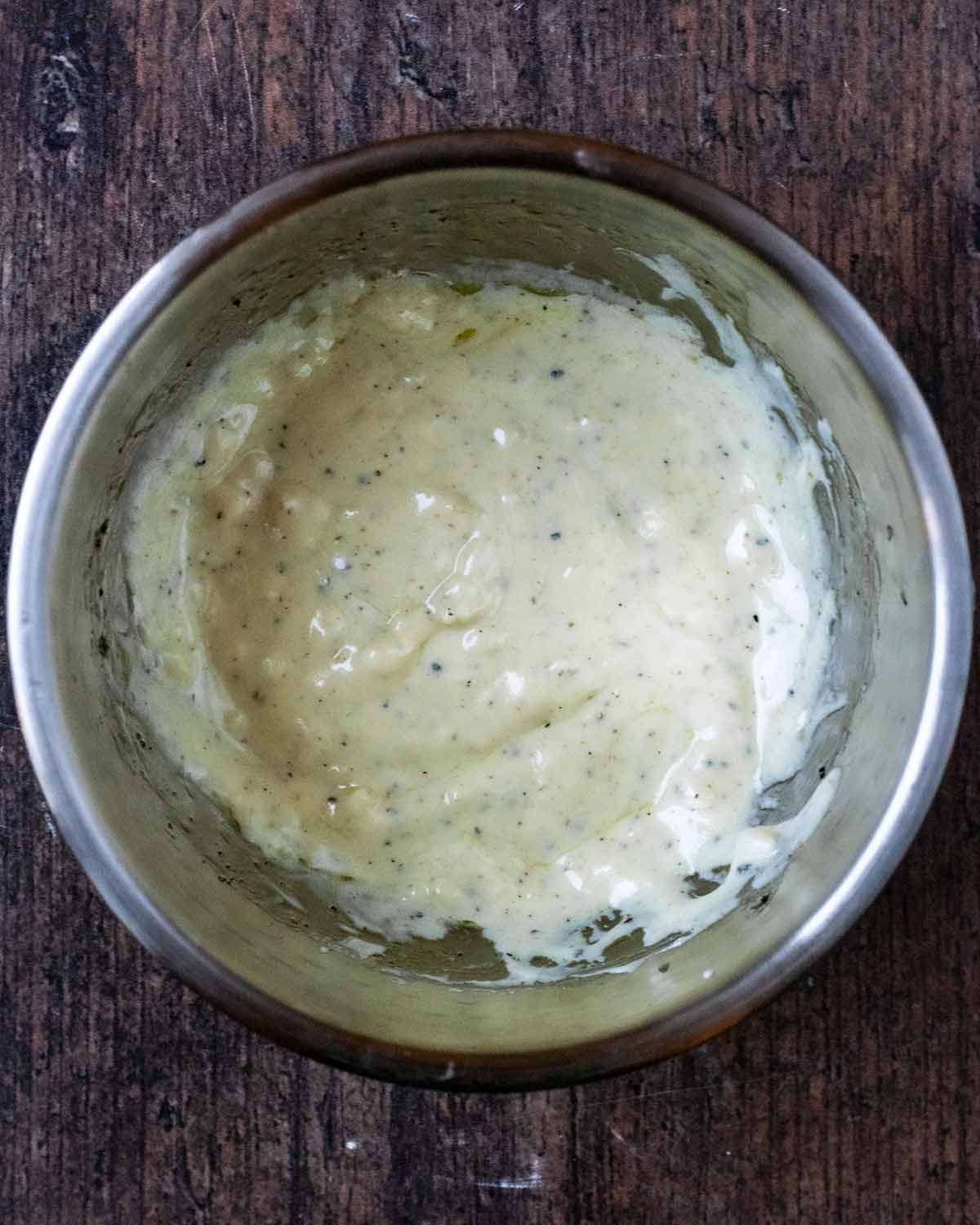 A small mixing bowl containing a creamy salad dressing.