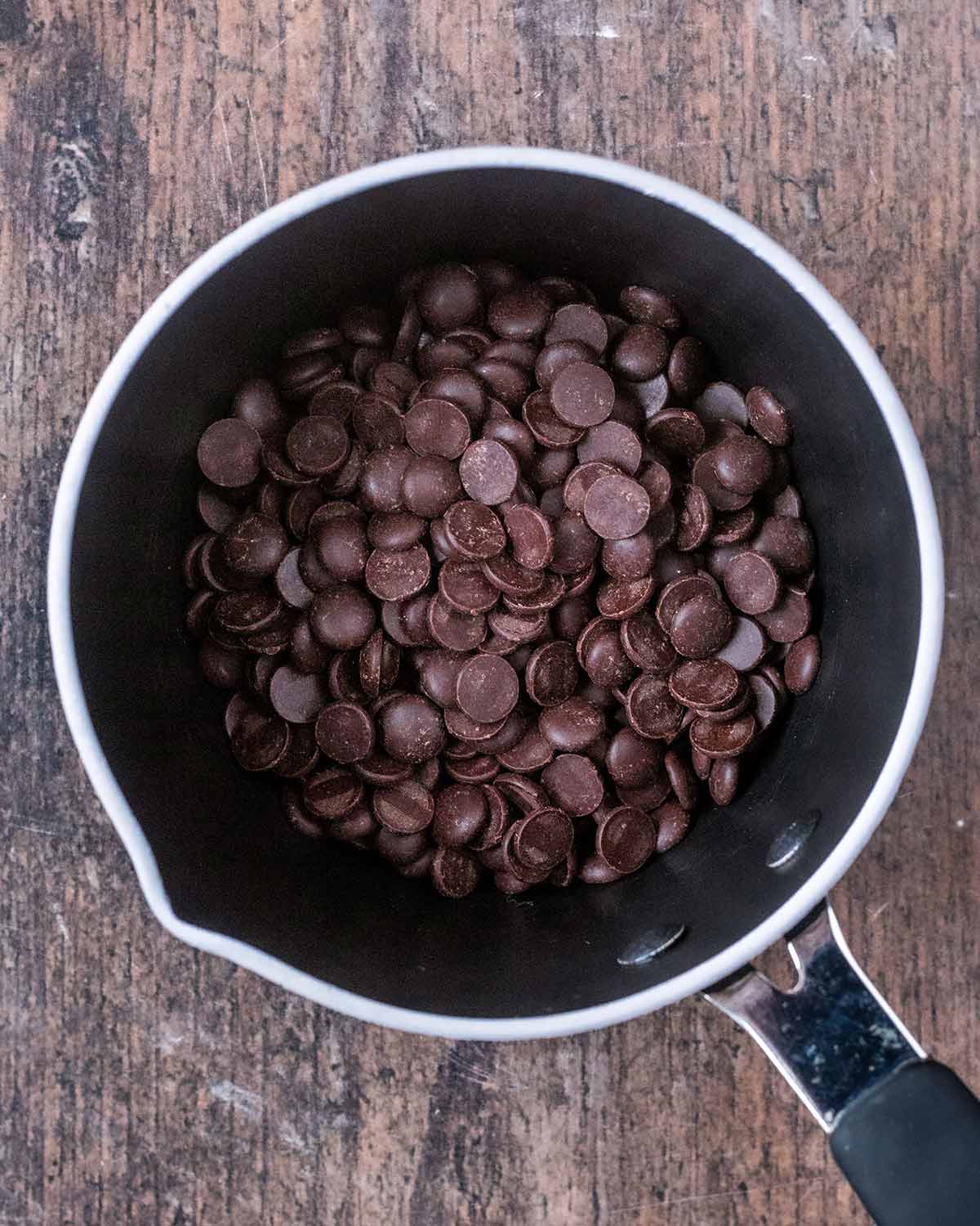 A small saucepan containing chocolate chips.